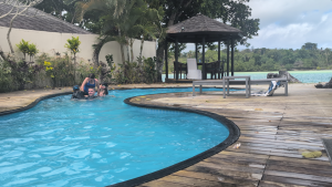Man enjoying the Efate Villa Pool with his two daughters and two nephews in Vanuatu